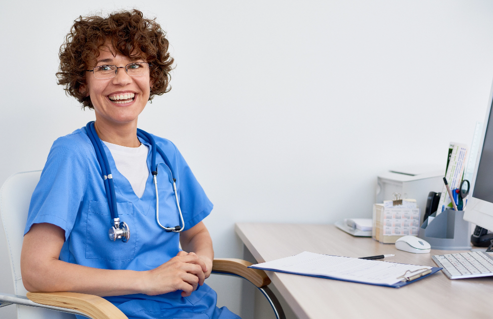 Smiling nurse seated at a desk